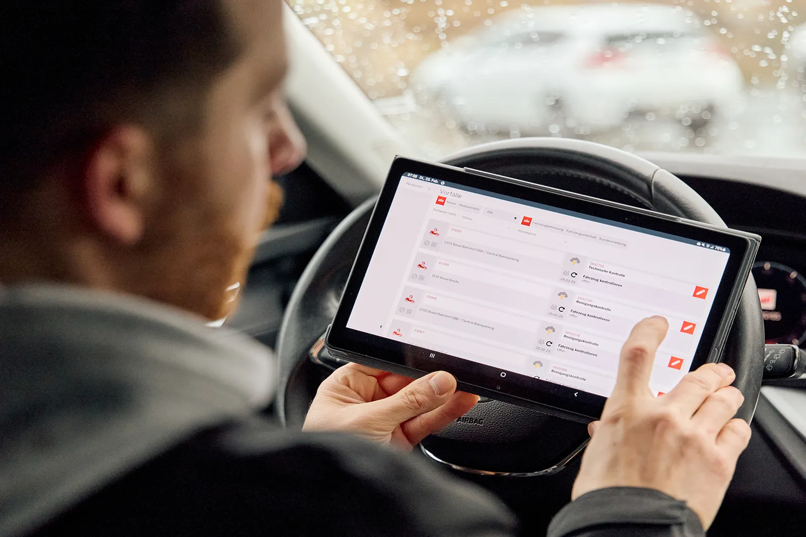 Un collaborateur du ServiceMobil consulte les données du véhicule sur sa tablette.