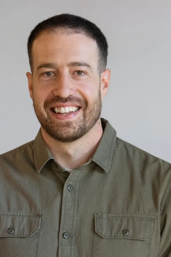 Luca Borra sourit à la caméra sur fond neutre.